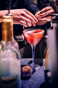 一位男酒保喝杯充满活力的红火热果子鸡尾酒亲手拍完图片