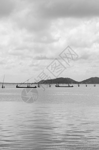 夏季和平的Songkhla湾海景渔民在船上用长的棍钓鱼图片
