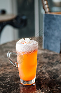 一杯茉莉菊茶橙色啤酒鸡尾上面有青白泡沫和茉莉花图片
