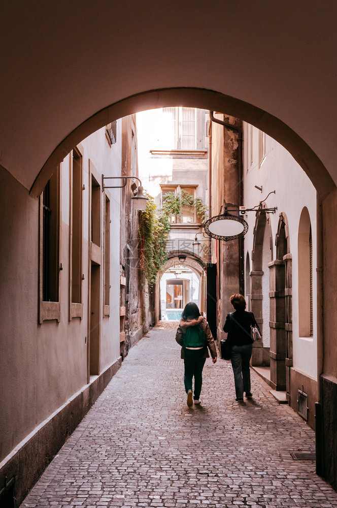 旅游者在老城区的小巷上行走图片