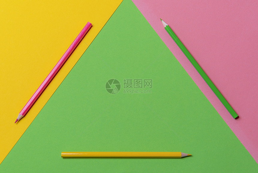 办公桌有三种颜色的木铅笔绿黄和粉红几何显示在一个三角形上在视图方有复制空间返回学校图片