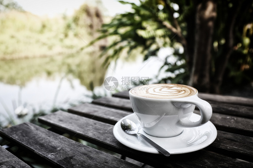 在河边木桌上的咖啡牛奶图片