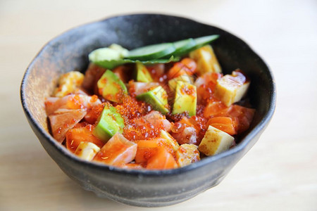黑瓷碗里的蔬果加鱼子酱和生鱼块图片