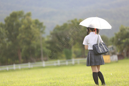 有雨伞的学校农村有草山和树背景图片