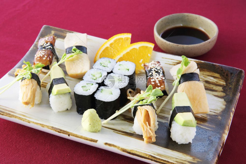红色桌布背景上的各类寿司图片