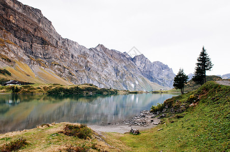 在Trubse湖岸边有小屋的农村风景观Swisalp在背景上爬着克劳山峰在安格尔堡的Titls山脚背景