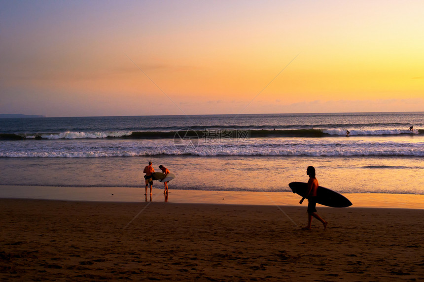 海滩上的冲浪者在风景日落巴利印地安图片