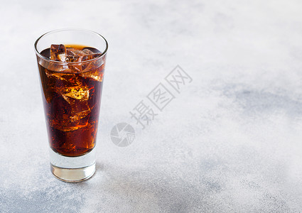一杯可乐苏打饮料冰块和泡沫在石器厨房背景图片