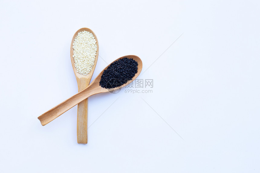 木勺上的黑芝麻和白种子背景图片
