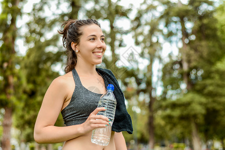 户外运动妇女健身后饮用水的肖像图片