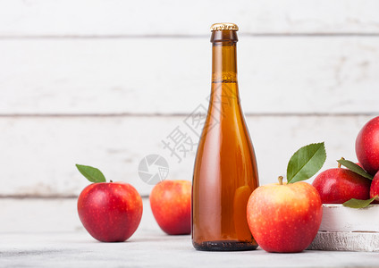 瓶装自制有机苹果和玻璃杯在木底的盒子里装有新鲜苹果玻璃装有冰块图片