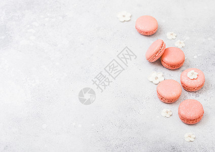 蛋白杏仁饼灰色粉红甜点蛋糕面或有白甜花的马卡龙在石器厨房背景上背景