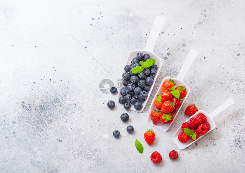 厨房桌上的白勺子中新鲜有机果子文本空间顶视图草莓蓝和薄荷叶图片