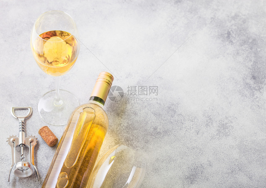 和白葡萄酒的瓶子和开器在石头厨房桌背景顶端视图图片