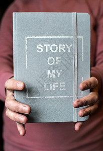 人生书女人拿着笔记本写我人生故事的笔记个人回忆录概念手拿着书背景