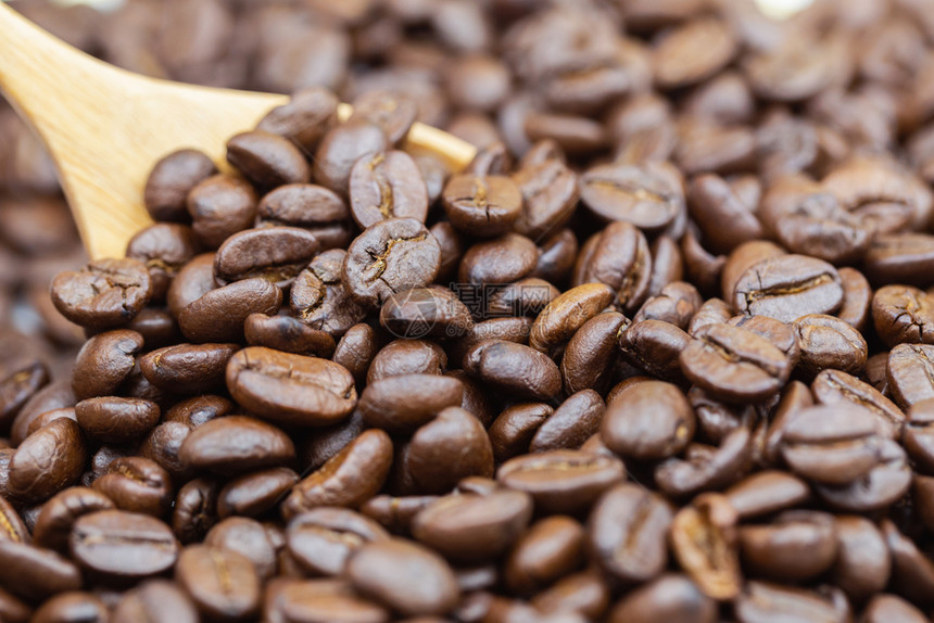棕色烤咖啡豆质料有木勺背景用于食品和饮料或农业概念设计图片