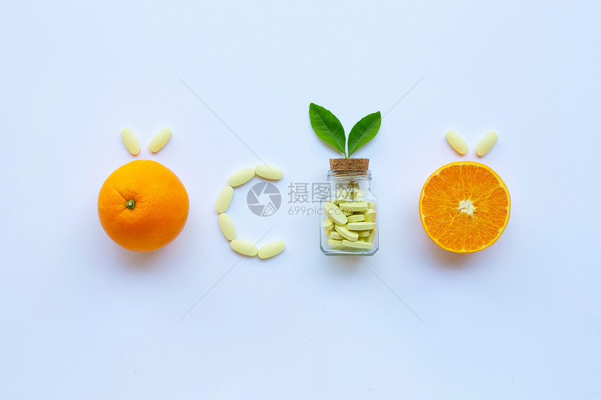 白底带橙果的维生素c瓶和药丸图片