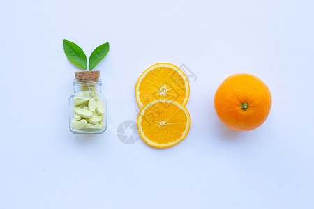 白底带橙果的维生素c瓶和药丸图片