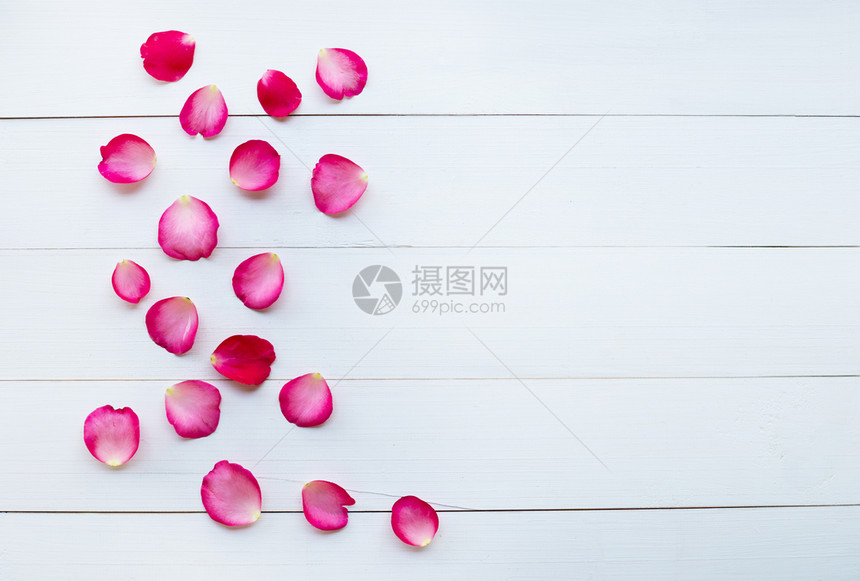 白木背景上的玫瑰花瓣图片