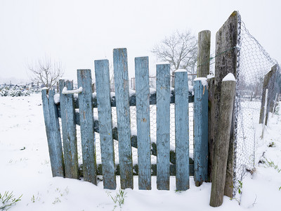 雪地上古老的荒凉黑漆蓝色木门图片