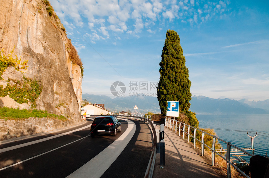 Swishzerland开在湖面的汽车韦镇附近的chexbrs村和Switzerland的Motreux路边有岩石悬崖图片