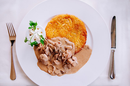 罗斯蒂奶油蘑菇肉汁酱和炸的罗索薯当地菜白盘背景