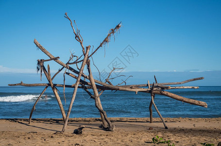 浮框Hanlei海滩上有冲浪器的漂浮木结构在材后面可见背景