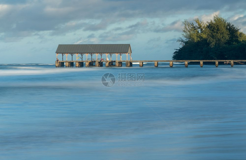 日出时亮哈纳雷码头上方的黎明天空照亮长期于哈纳雷卡瓦伊哈附近的模糊波浪之下图片