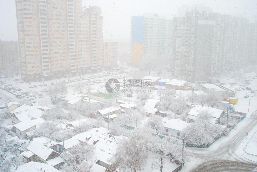住宅区冬季降雪与城市现代化公寓楼和旧私人住宅kievuraine形成对比图片