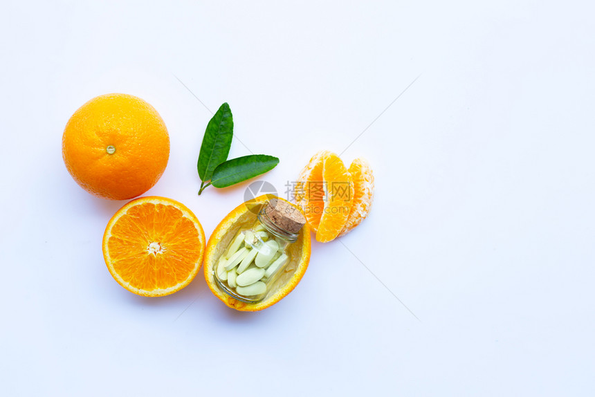 白底带橙子水果的维生素C瓶和药丸复制空间图片