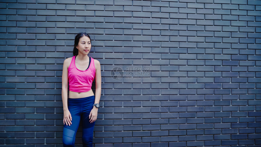 身穿运动服的年轻健康女运动员在服腿上变暖手臂伸展准备在城市街头奔跑活跃的生方式妇女在城市概念中运动图片