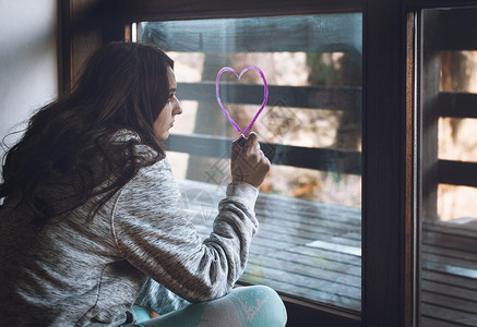 女孩在窗户上画着爱心图片