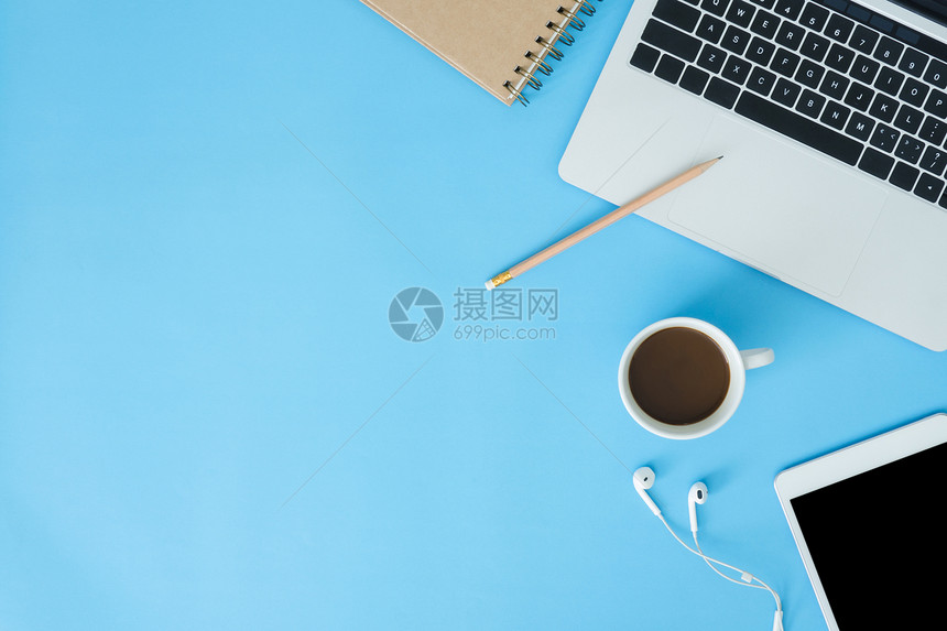 办公桌工作空间平面用笔记本电脑智能装置和一杯咖啡拍摄工作空间蓝色面平图片