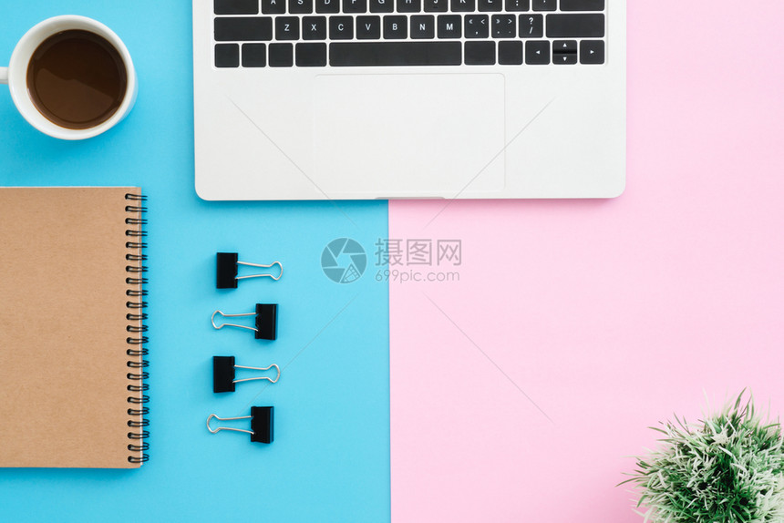 工作空间办公桌的顶层有笔记本电脑剪辑笔记本咖啡杯和以蓝色粉背景植入的物图片