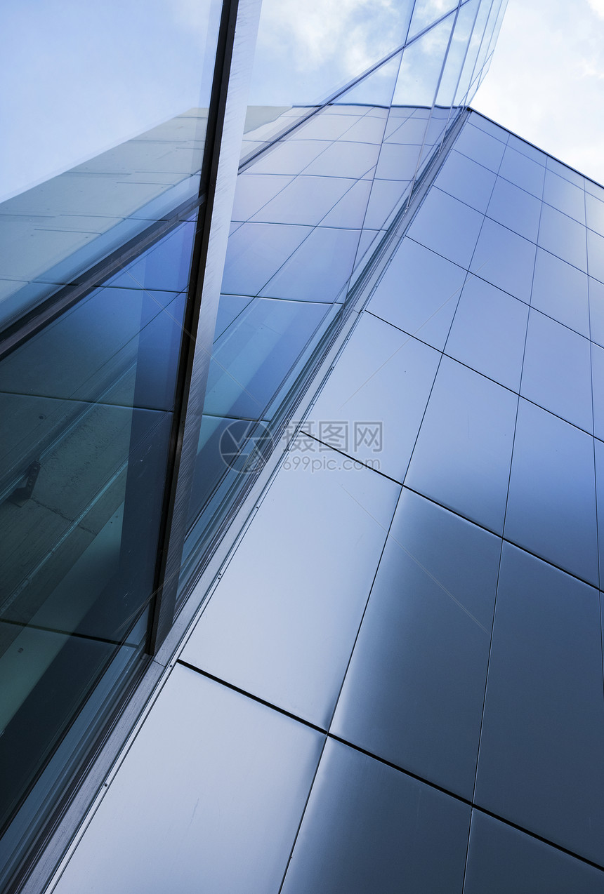 现代公司办大楼的玻璃和钢反映蓝色天空和云彩图片