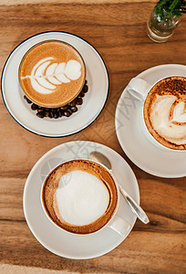 美丽的热咖啡拿铁奶质很好咖啡豆和杯加卡布奇诺放在木制桌上最亮的镜头中图片