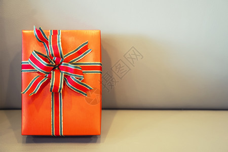 在沙发上有红丝带的大礼物盒免费空间假日和庆祝背景图片