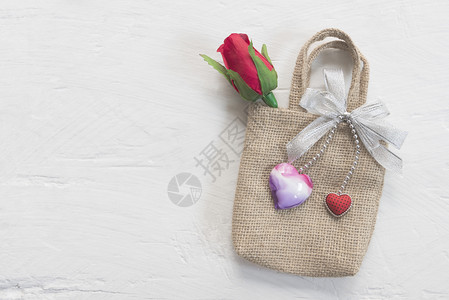 红色袋子情人节爱和婚礼背景概念红玫瑰和小袋子上的心放在白木桌上图片用于添加文字信息设计艺术工作的背景背景