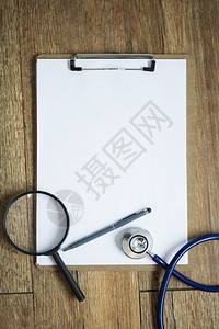 桌子上的空白笔记本有听诊镜的放大医学背景概念图片