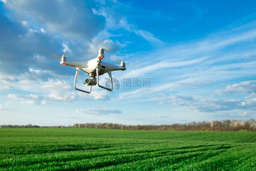 无人驾驶飞机在小麦田上飞行图片