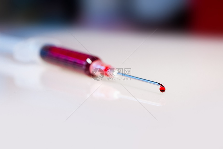 注射针筒头带血滴的宏观视图注射针头带血滴的宏观视角图片