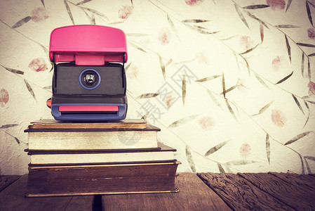 古老的旧书相机贴在甜彩纸背景上图片