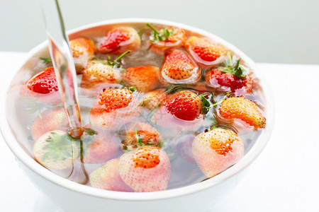 浸在水里的草莓洗新鲜水果白色图片