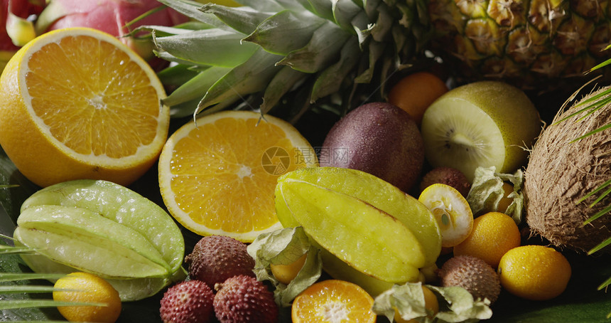 在新鲜的有机天然异国水果上浇近距离视频全景运动4kuhd视频3840216p素食饮的概念各种热带水果橙子菠萝卡拉博椰子和带水的乳图片