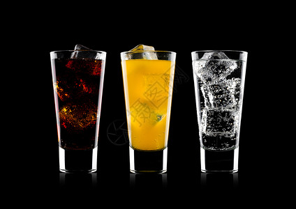 一杯可口乐橙苏打饮料和柠檬水用冰块在黑色底的面闪光水和冰块图片