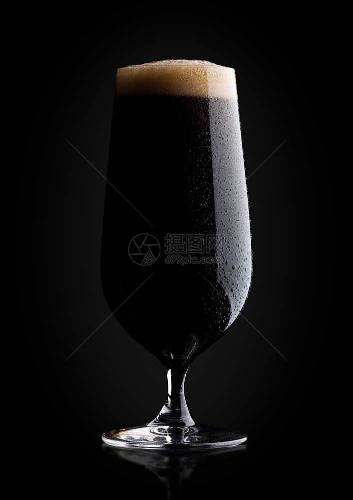 含泡沫和露的黑底面反光啤酒图片