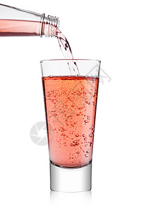 将粉色苏打汽水柠檬从瓶子倒到白底玻璃图片