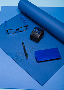 蓝色时装风格仍然以蓝色背景为生活设置带眼镜电话和笔图片