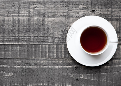 木制背景的黑杯健康茶图片