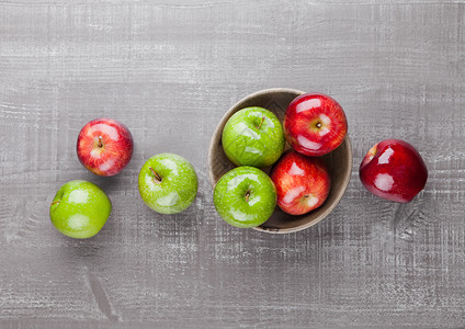 木板碗中的红苹果和绿苹果图片
